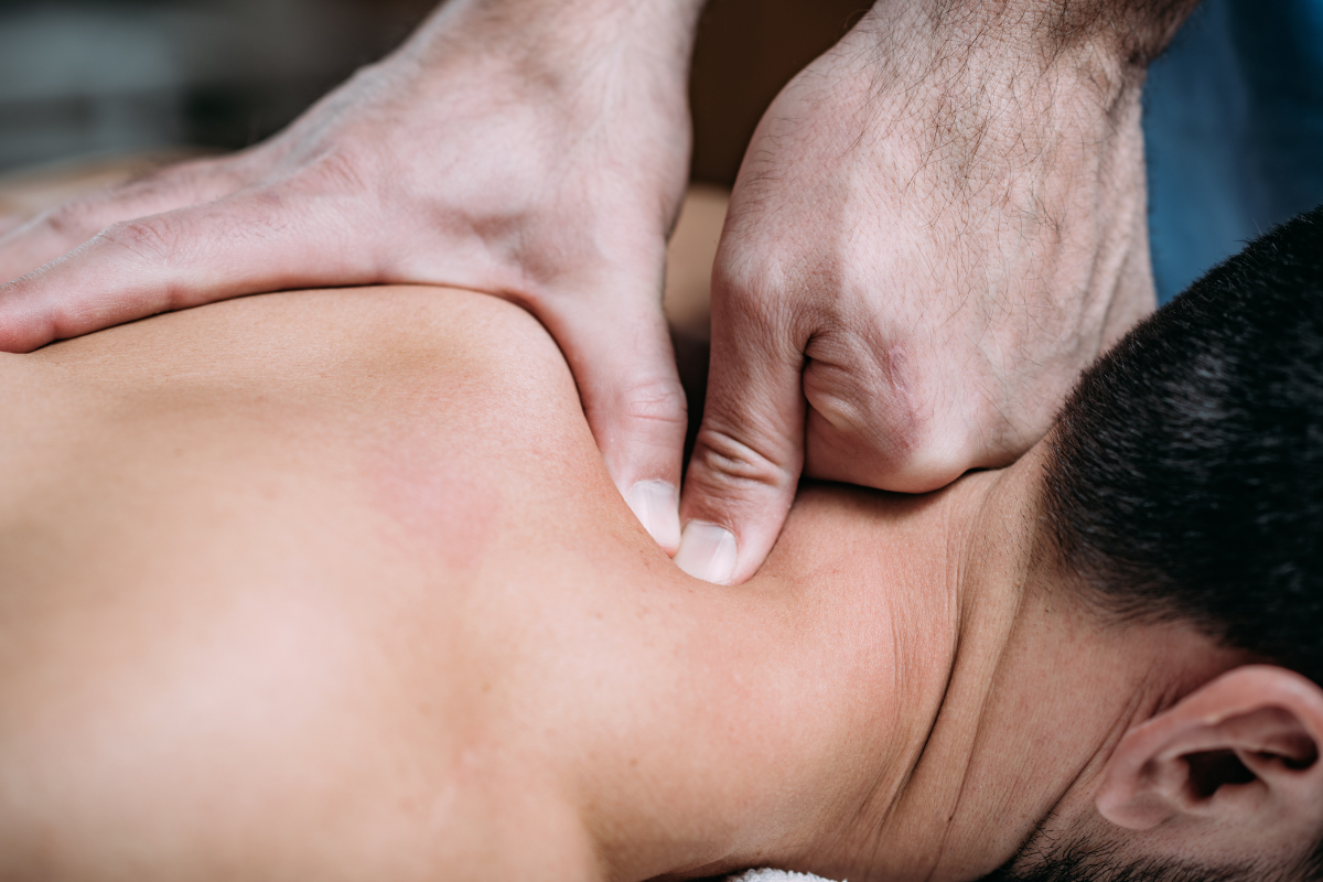 Massothérapeute travaillant une tension musculaire à l'aide de ses pouces